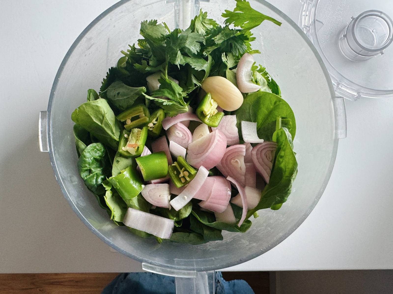 Mixing green sauce in a food processor.