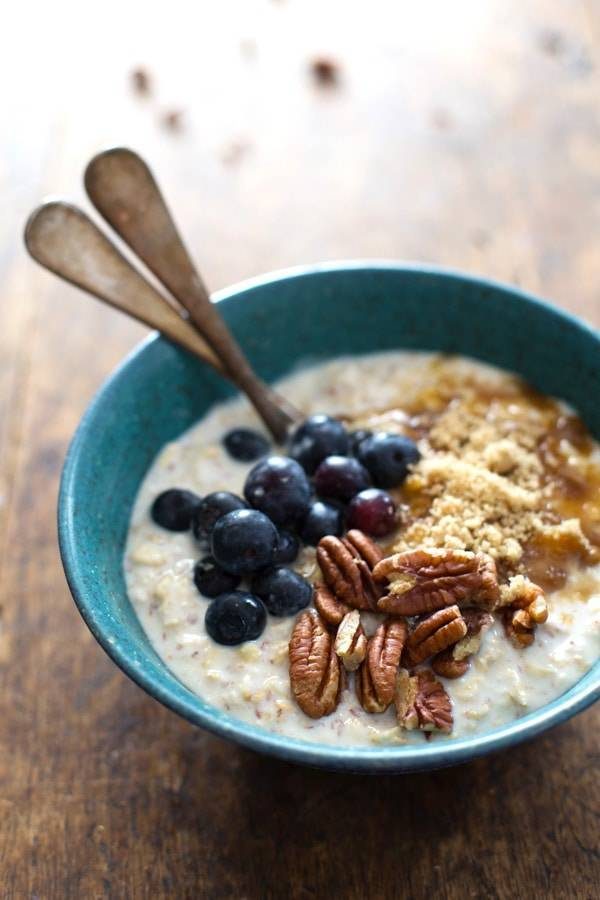 Flax and Blueberry Vanilla Overnight Oats in a blue bowl with spoons.