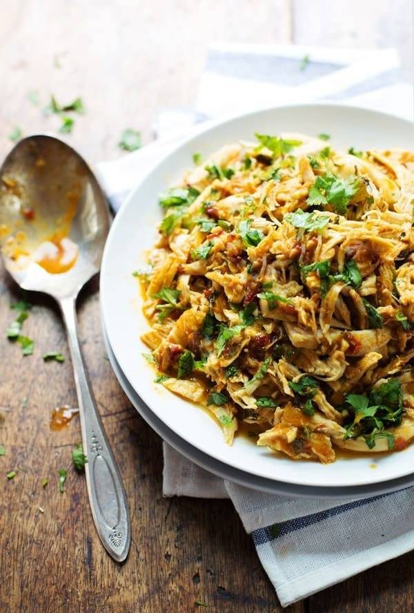 Spicy Chipotle Shredded Chicken on a white plate with a spoon.