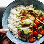 Salmon with basil sauce, tomato salad, and rice in a bowl